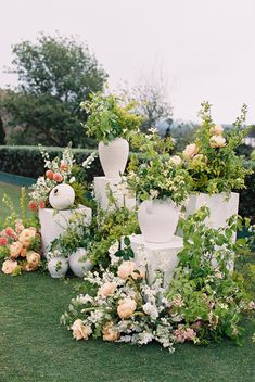 an arrangement of vases and flowers on the grass