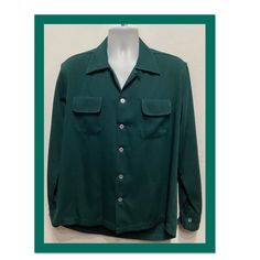 "1950s vintage reproduction dark green Gabardine Shirt with top stitching by Hollywood Rogue This classic 1950's reproduction gabardine shirt is a dark green and has a pointed loop collar, two rounded flap pockets,  five button down front and long sleeves with double button cuffs. The shirt features contrasting white hand finished top stitching on collar and pockets.  This shirt as with all clothing made by \"Hollywood Rogue\" was made to look exactly like an original 1950s garment. The label reads \"Hollywood Rogue\" and the shirt is in new unworn condition. Made in the USA. Please see measurements below as these shirts tend to run large. Size Small MEASUREMENTS: (All measurements were taken lying flat) Shoulders - 18.5\" (measured on back of the shirt from seam to seam) 20\" (measured fr Vintage Green Button-up Shirt, Green Snap Button Shirt For Fall, Classic Green Johnny Collar Tops, Classic Green Shirt With Button Cuffs, Retro Green Button-up Shirt, Retro Solid Color Shirt With Button Closure, Retro Solid Shirt With Button Closure, Classic Green Top With Camp Collar, Fitted Green Shirt With Camp Collar