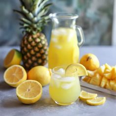 a pitcher of lemonade next to sliced pineapple