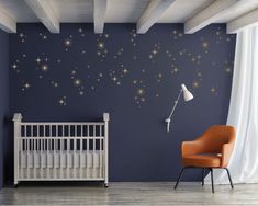 a baby's room with stars painted on the wall and a crib next to it