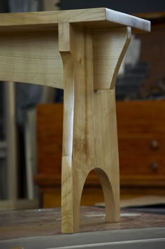 a wooden table with a piece of wood sticking out of it's leg and legs