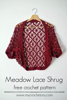 a red crocheted sweater hanging on a hanger with the text meadow lace shrug free crochet pattern