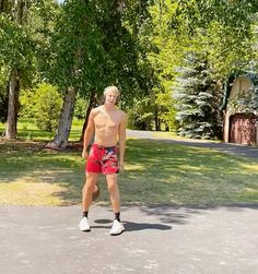 a man with no shirt is playing frisbee in the park on a sunny day