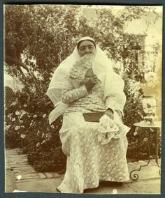 an old black and white photo of a woman sitting on a bench