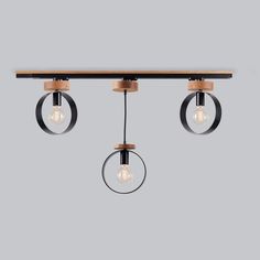 three lights hanging from the ceiling with two circular light bulbs on each end and an oval wooden