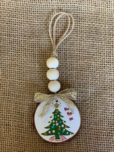 a ceramic ornament with a christmas tree hanging from it's side on a burlap background