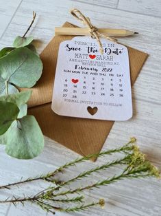 a calendar on a piece of brown paper next to some green leaves and a pair of scissors