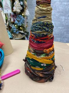 a stack of different colored yarn next to a pink pen