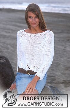 a woman sitting on top of a rock near the ocean