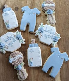 decorated cookies are arranged in the shape of baby's feet and onesuits