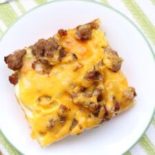 a white plate topped with a piece of cheese and meat casserole