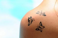 the back of a woman's shoulder with butterflies on it