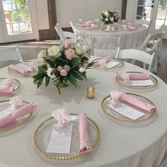 the table is set with pink napkins and place settings for guests to sit at