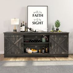 an entertainment center in a living room with wine bottles on the shelves and a poster above it