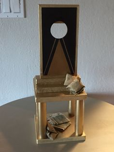 a miniature chair sitting on top of a table with stacks of money in front of it