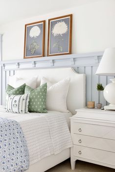 a bedroom with two framed pictures above the bed and nightstands on either side of the bed