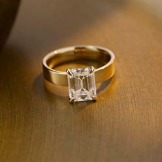 a gold ring with an emerald cut diamond