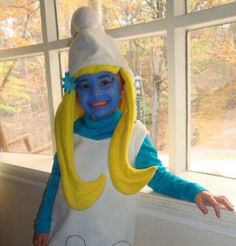 a child in a costume standing next to a window