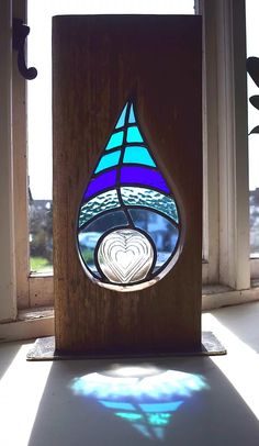 a stained glass window sitting on top of a wooden block