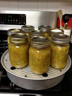 six jars filled with food sitting on top of a stove