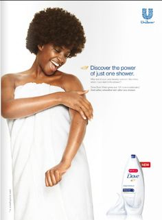 a woman wrapped in a white towel holding a bottle of dove's body wash