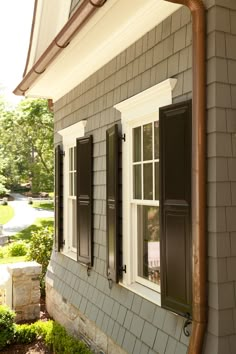 a house with black shutters and white trim on the windows is featured in an instagram