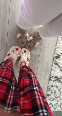 two people wearing plaid pants and slippers standing in front of each other on the floor