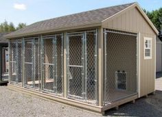 a dog kennel is shown in the middle of a gravel lot with two dogs inside