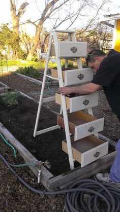 a man is working on drawers in the garden