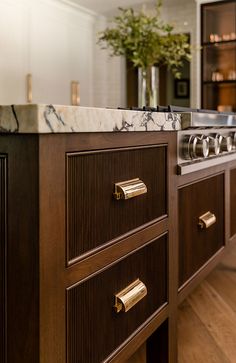 a kitchen with marble counter tops and brass pulls on the cabinet doors is pictured in this image