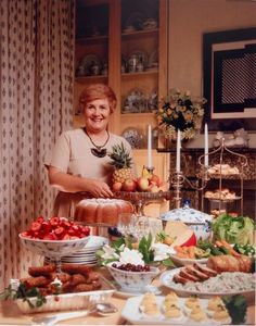 a woman standing in front of a table filled with food