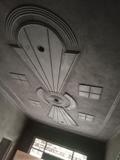 the ceiling in this room is made from concrete and has an intricate design on it