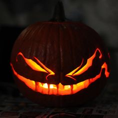 a carved pumpkin with glowing eyes on it