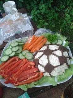 a platter with carrots, cucumbers, and other food on it