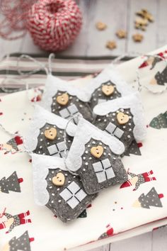 three gingerbread house ornaments on a table