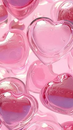 many pink hearts floating in the air with water droplets on them to create a heart shape