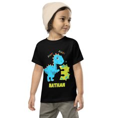 Welcome his next birthday in style customized to reflect his interest.  Cool customized tee for your little ones.  Let your toddler do their thing while feeling super comfy and looking extra stylish in this short-sleeve jersey t-shirt from 100% cotton with a unique print. The tee is soft, durable, and bound to become the staple of your toddler's wardrobe.  * 100% combed and ring-spun cotton * Fabric weight: 4.2 oz/yd² (142 g/m²) * Relaxed fit for extra comfort * Side-seamed construction * Pre-shrunk fabric * Blank product sourced from the US or Honduras This product is made especially for you as soon as you place an order, which is why it takes us a bit longer to deliver it to you. Making products on demand instead of in bulk helps reduce overproduction, so thank you for making thoughtful Crew Neck T-shirt With Dinosaur Print For First Birthday, First Birthday T-shirt With Dinosaur Print, Green Dinosaur Print T-shirt For Birthday, Dinosaur Print Short Sleeve T-shirt For First Birthday, Birthday T-shirt With Dinosaur Print, Dinosaur Print Short Sleeve T-shirt For Birthday, Birthday Dinosaur Print Short Sleeve T-shirt, Dinosaur Outfit, Blue Dinosaur Print Short Sleeve T-shirt