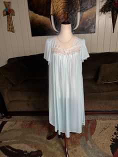 Miss Elaine Silk Essence Size Large Innocence Look Blue Nightgown. This is a beautiful nightgown that feels silk against your skin. It has white floral lace trim. This nightgown is in MINT condition with NO tears or stains  on the fabric!!  Details: 1.) Breast: 40" inches  2.) Shoulder to shoulder: 13" inches  3.) Shoulder to hem: 38" inches  4.) Sleeve Length: 12" inches  5.) Waist: 54" inches  6.) Hip/ Thigh: 70" inches  7.) 100% Polyester  8.) Machine washable 9.) Made in China  Thanks for lo Elegant Nightgown With Lace Trim For Home, Elegant Lace Nightgown For Home, White Lace Sleepwear For Home, Blue Lace Nightgown For Loungewear, Blue Lace Nightgown For Sleep, White Lace Nightgown, Blue Nightgown, Beautiful Nightgown, Lace Nightgown