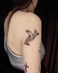 a woman with a bird tattoo on her arm