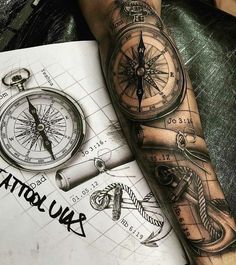 a man with a compass tattoo on his arm next to an open notebook and pen