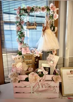 a teddy bear sitting on top of a wooden box next to a baby's dress