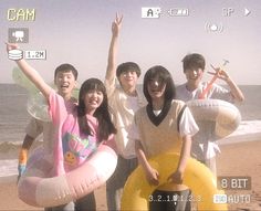 a group of people standing on top of a beach next to an inflatable raft