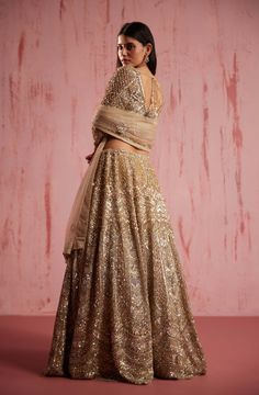 Experience the captivating charm of this ethereal and enchanting zayan gold lehenga, exquisitely inspired by the floral embroidery. Embellished with a mesmerising sequenced hand done floral motifs and gold embroidery, this lehenga showcases the pinnacle of artistry. The elegant blouse is further enhanced with intricate embroidery all over. A masterpiece to cherish! The outfit showcases effortless beauty, creating a harmonious and distinctive look. Gold Lehenga, Effortless Beauty, Elegant Blouses, Intricate Embroidery, Gold Embroidery, Gold Fabric, Bridal Lehenga, Floral Motifs, Indian Design