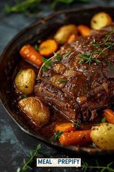 a pot roast with carrots and potatoes on a black plate, ready to be eaten