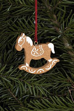 a wooden ornament hanging from a christmas tree with a horse on it's back