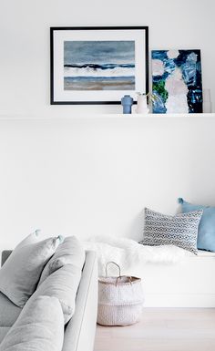 a living room filled with furniture and pictures on the wall