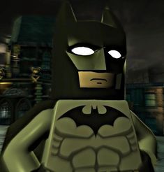 a lego batman standing in front of a building at night with the light on his face