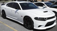 two white cars parked next to each other in a parking lot