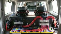 the back end of a car with two subs and wires in it's trunk