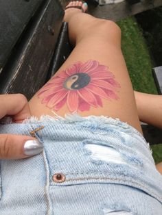 a woman's back with a flower tattoo on her left side and the bottom half of her stomach